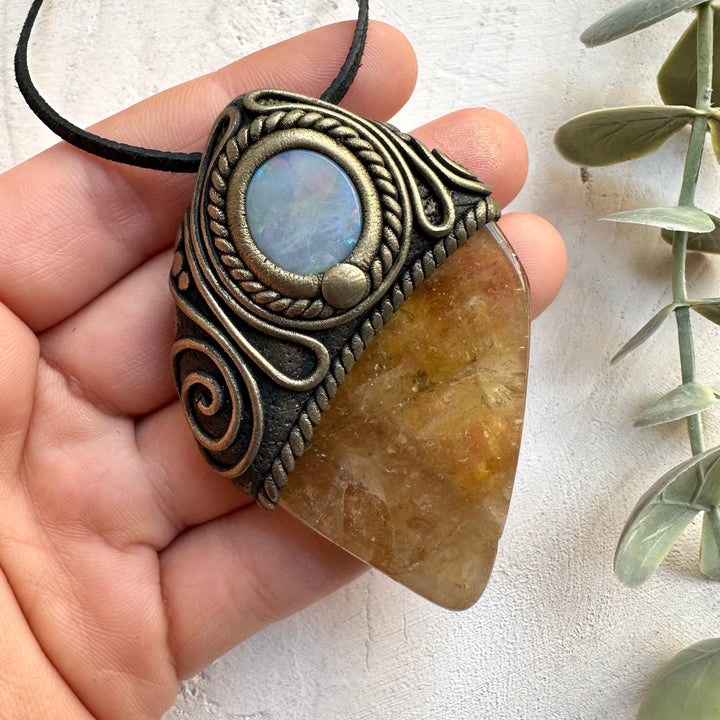 Close up of polished citrine and gray Australian opal crystal pendant