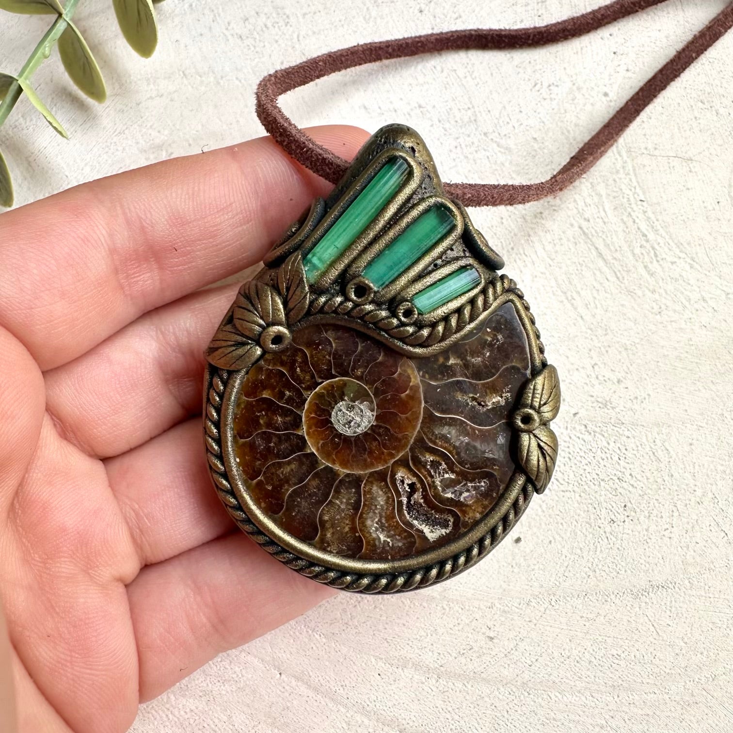 Natural green tourmaline spiritual necklace paired with ammonite fossil pendant and healing crystals