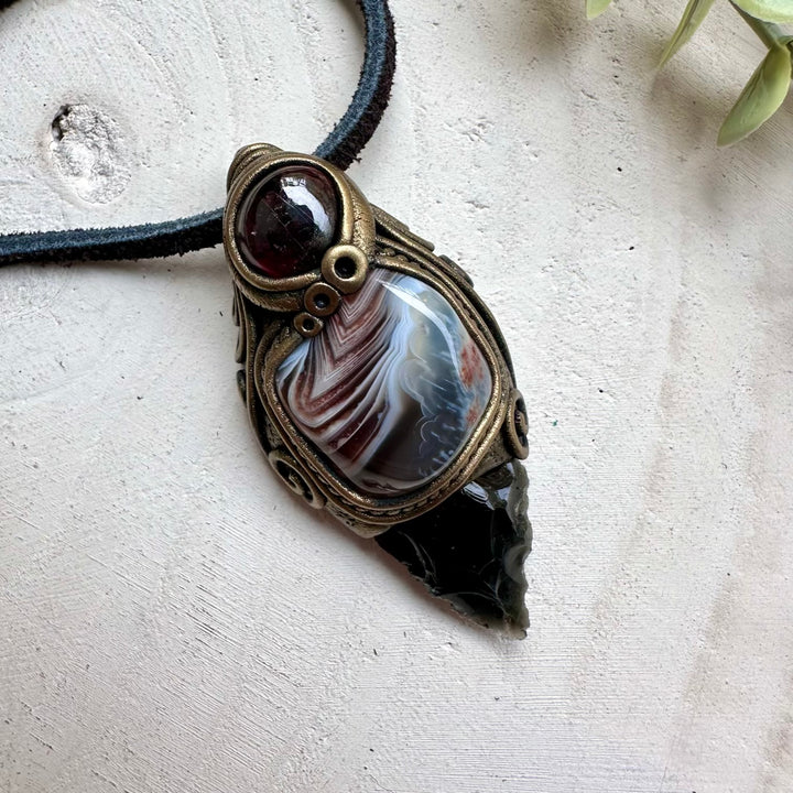 Obsidian arrowhead paired with botswana agate and rhodolite garnet