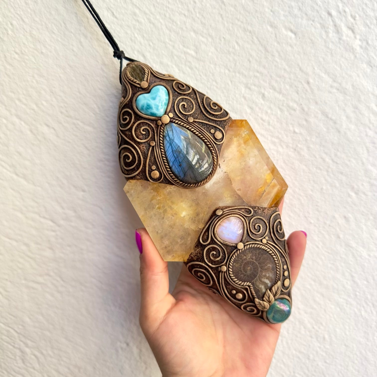 Handmade wall art with healing crystals and ammonite fossil