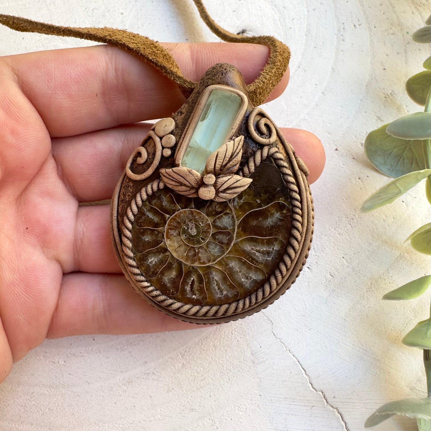 Close up of ammonite and aquamarine pendant necklace