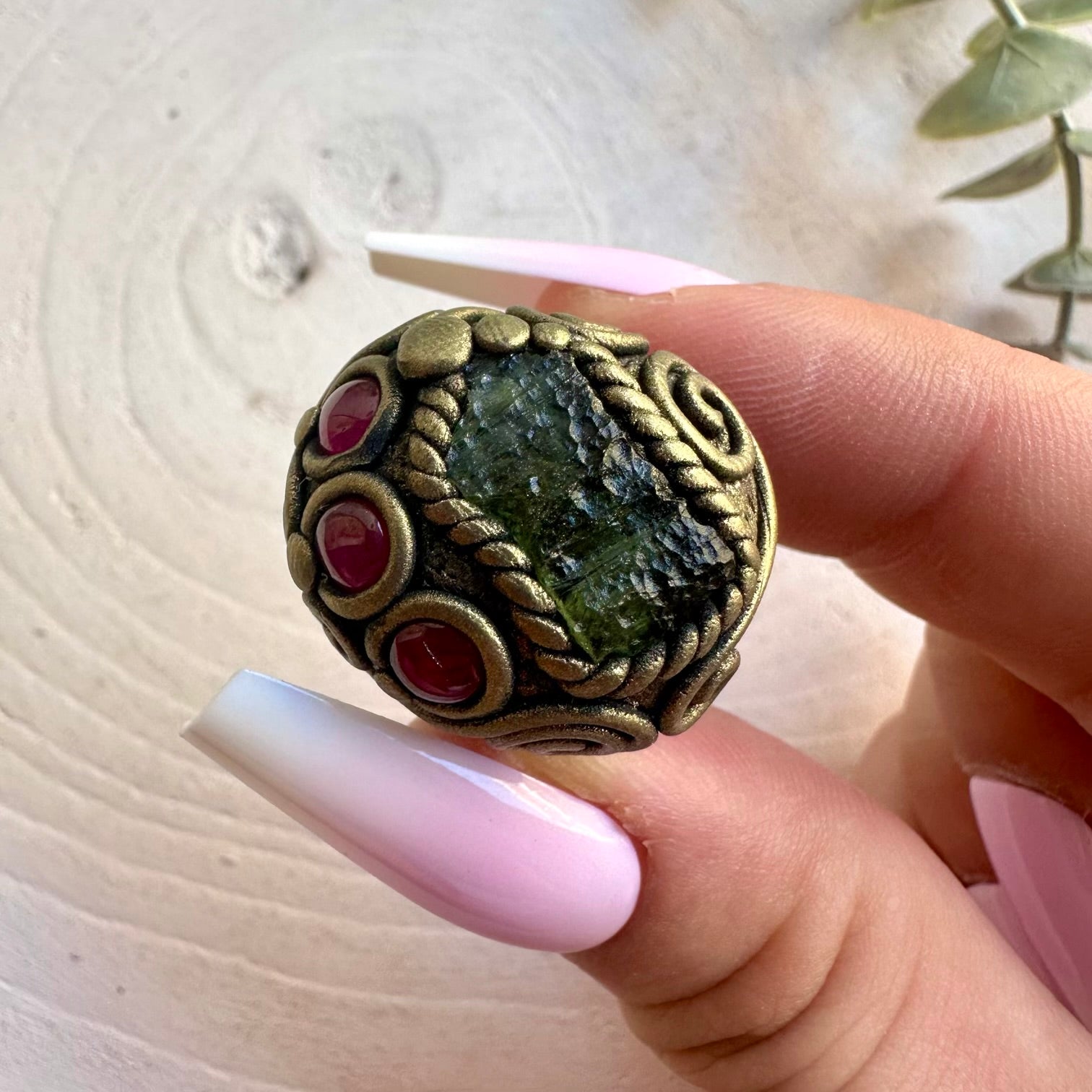 Handmade gemstone ring combining distinctive green Moldavite with rich red Rhodolite Garnet.