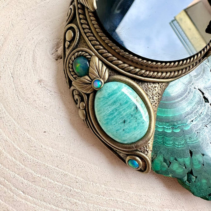 Handmade healing crystal home decor featuring a Black Obsidian mirror surrounded by natural Malachite and colorful gemstones.