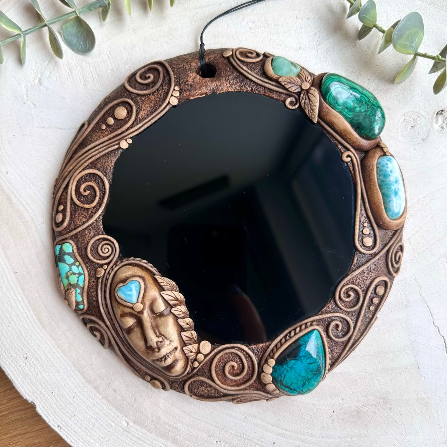 Close up of goddess crystal wall hanging with ocean and earth stones
