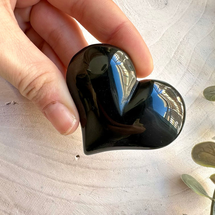 Close up of polished rainbow obsidian heart crystal