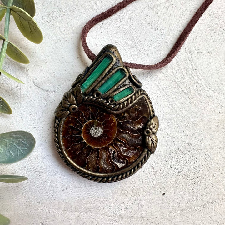 Raw healing crystal necklace featuring green tourmaline stones and ammonite fossil pendant