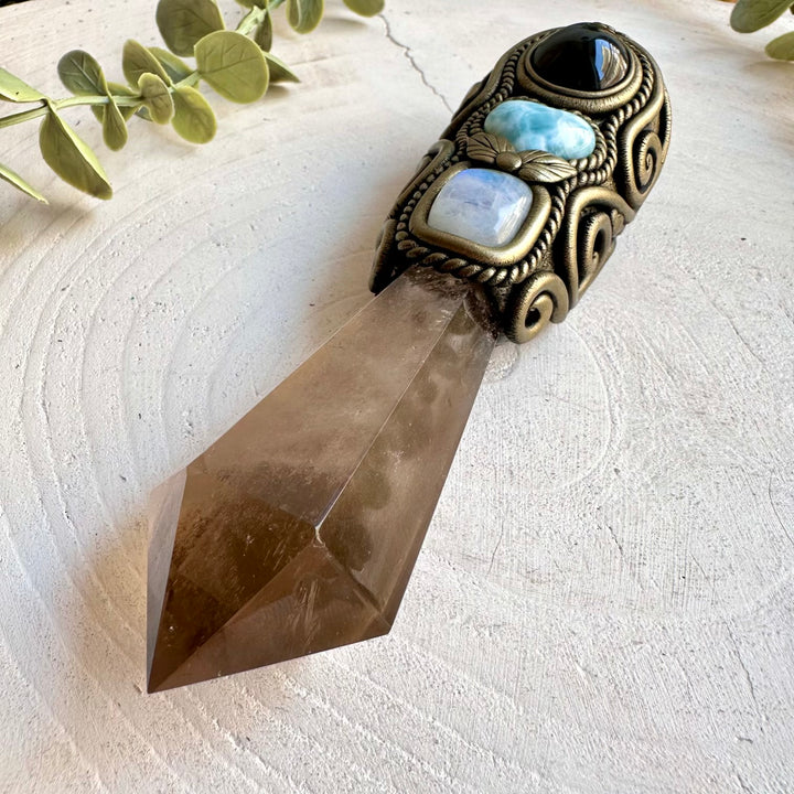 Handmade Smoky Quartz crystal wand featuring an Aqua Aura Spirit Quartz Cluster, Larimar Heart, Rainbow Obsidian, Rainbow Moonstone and Australian Opal. A one of a kind metaphysical healing crystal tool designed for meditation, energy work, manifestation, Wiccan rituals and Pagan altar practice.