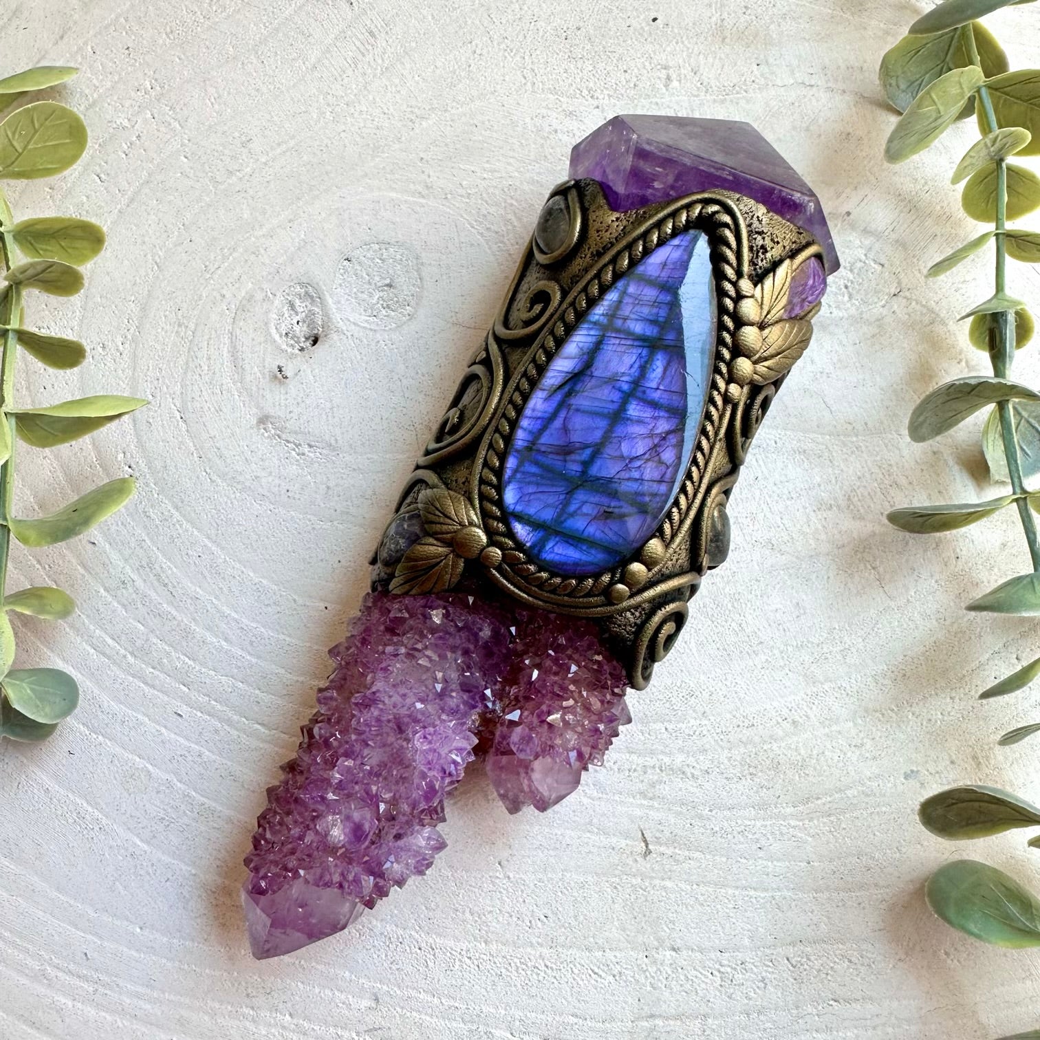 Healing crystal tool designed with Tanzanite, Clear Topaz and Amethyst in an artistic setting.