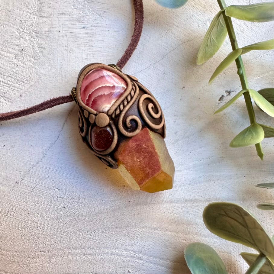 Handmade metaphysical crystal necklace featuring sunset aura quartz rhodochrosite and sunstone