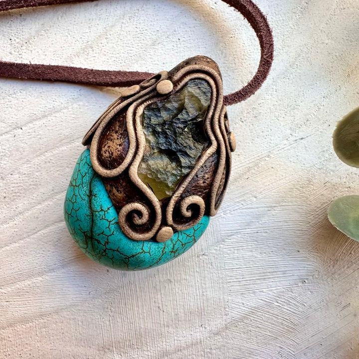 Turquoise gemstone paired with moldavite in a unisex clay necklace